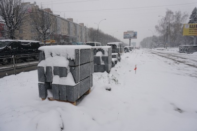 У Чернівцях робітники у снігопад встановлюють бордюри на проспекті - фото