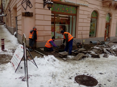 Сніг роботі не завада: на вулиці Кобилянської робітники встановлюють плитку
