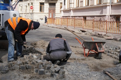 На вулиці в центрі Чернівців комунальники перекладають бруківку – фото